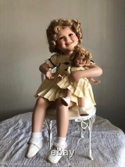 Porcelain Shirley Temple doll with her doll. On chair